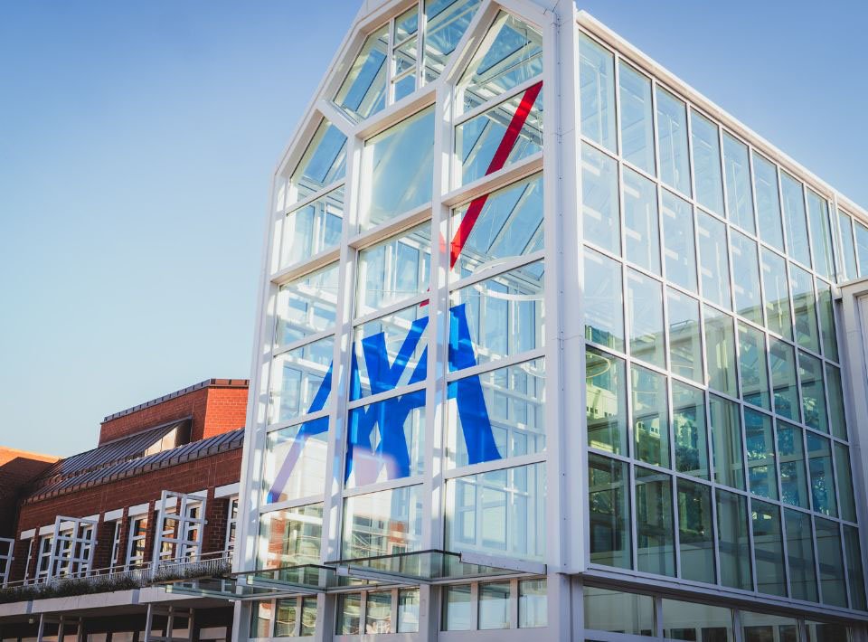 Die offene Eingangshalle vom AXA Campus in Köln wird von der Sonne angestrahlt.