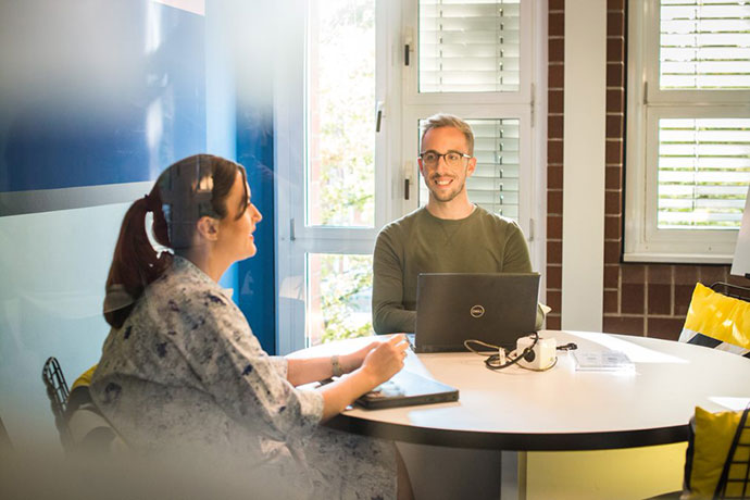 Ausbildungsleiter führt ein Feedbackgespräch mit Auszubildender