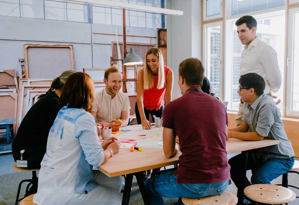 Tech-Team sitzt an Tisch bei einem Brainstorming