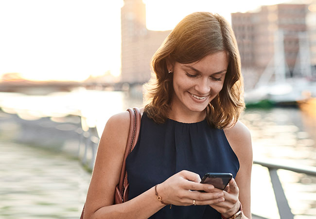 Junge Frau schaut auf ihr Handy