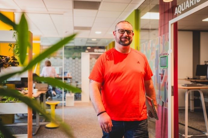 Recruiter Markus geht dynamisch über einen Flur auf dem AXA Campus