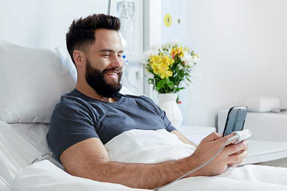 Vater sitzt bei Tochter am Krankenbett