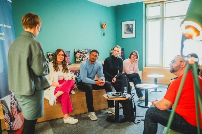 Mitarbeitende unterschiedlicher Herkunft, verschiedenen Alters & Geschlechts tauschen sich aus