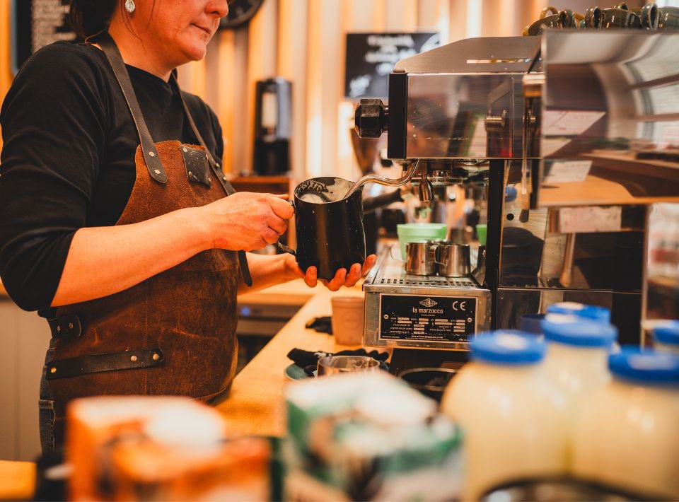Ein Barista macht einen Kaffee an einer Siebträgermaschine